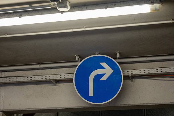 istock Turn right sign indicates direction in parking garage 2211391312