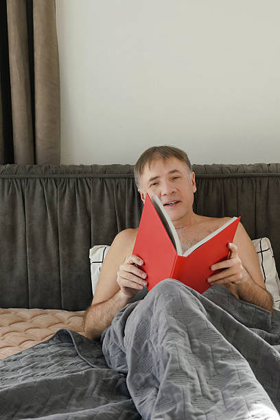 istock Enjoying a peaceful morning reading a book in bed with cozy blankets. 2211392237
