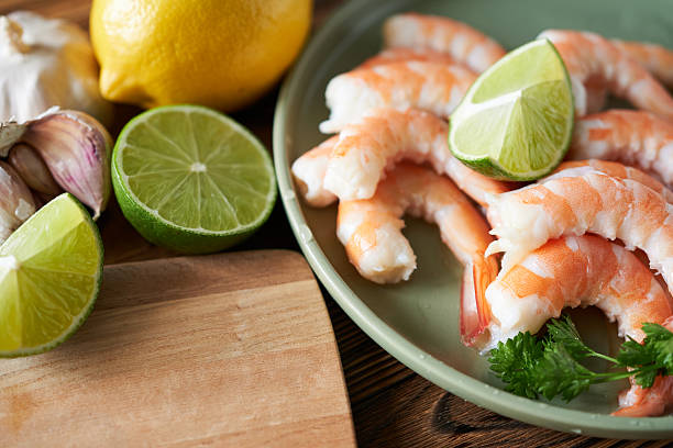 istock Fresh shrimps with lime and parsley on plate, closeup 2211396871