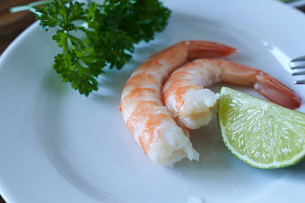 istock Shrimp with lime and parsley on a white plate close up 2211396884