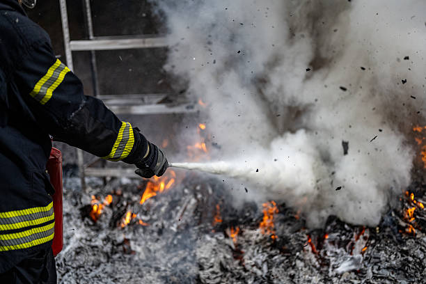 istock Fireman Extinguishing Flames with Fire Extinguisher 2211397916