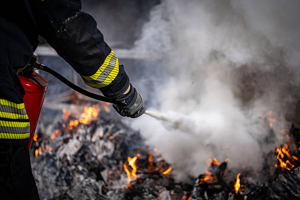 istock Fireman Extinguishing Flames with Fire Extinguisher 2211397923