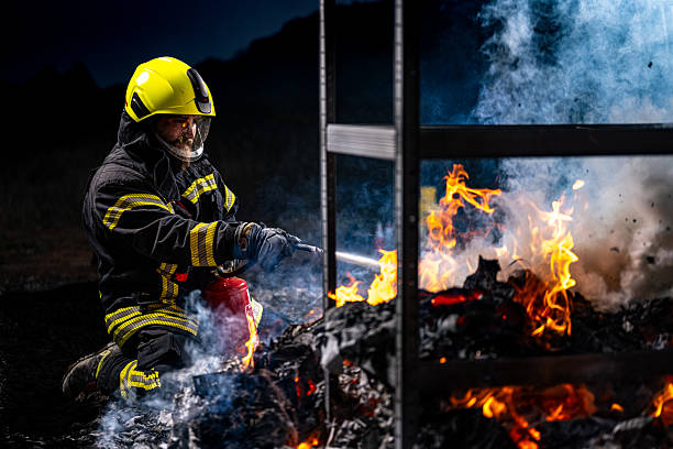 istock Fireman Actively Extinguishing Flames with Fire Extinguisher 2211397933