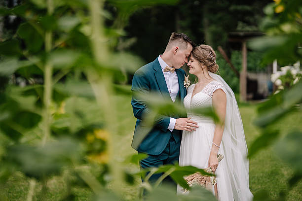 istock Bride and groom share a quiet forehead-to-forehead moment, framed by soft greenery. A tender and emotional outdoor wedding portrait. 2211398526