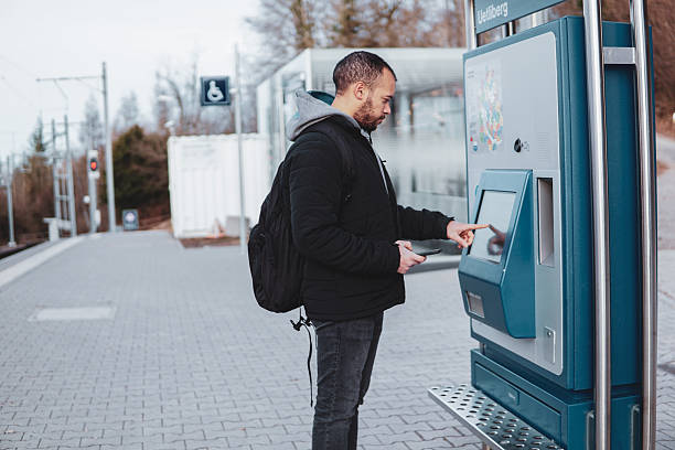 istock Traveler using ticket machine at train station. Man buying a ticket 2211402291