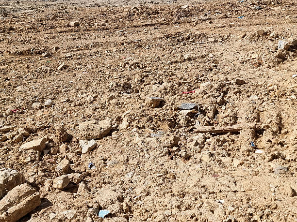 istock Arid Barren Land with Dry Cracked Soil and Scattered Rocks under Bright Sunlight 2211402485