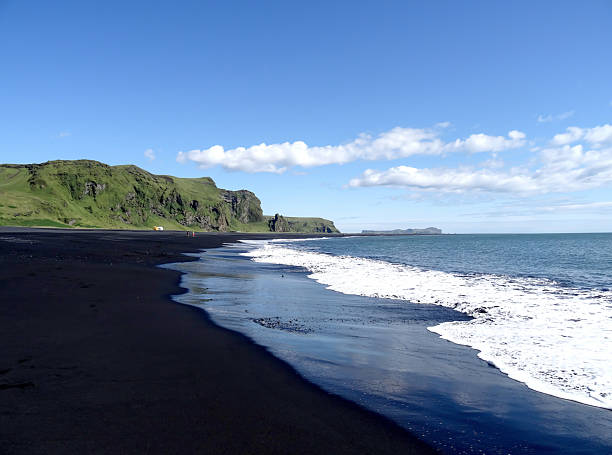 istock Black sand beach in Iceland with cliffs and ocean waves under a clear blue sky showcasing natural beauty and tranquility concept 2211405971