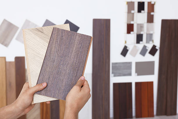 istock Man with different samples of wooden flooring indoors, closeup 2211408346