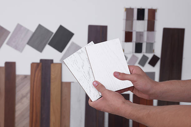 istock Man with different samples of wooden flooring indoors, closeup 2211408354