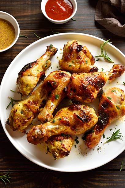 istock Barbecued chicken drumsticks on wooden table 2211411182