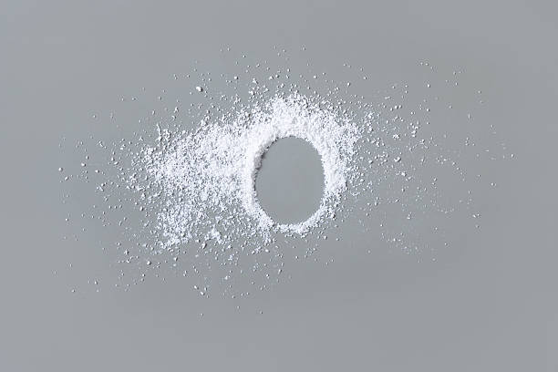 istock White powder on grey with copy space in middle top view. Dietary supplement or kitchen spice 2211411524