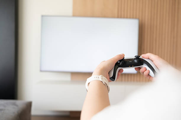 istock An individual engaged in playing video games using a controller within their living room space 2211411798