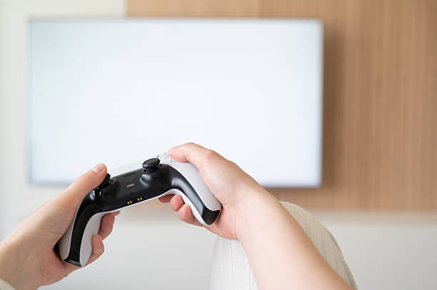 istock Enjoying a Relaxing Gaming Experience with a Controller and a Large Screen TV Setup at Home 2211411860