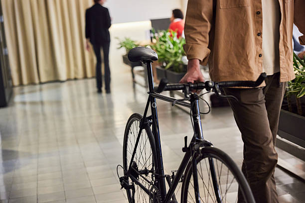 istock An unrecognizable person is walking with a bicycle in the office. 2211412428