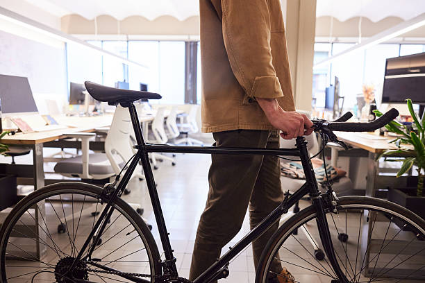 istock An unrecognizable person is walking with a bicycle in the office. 2211412446