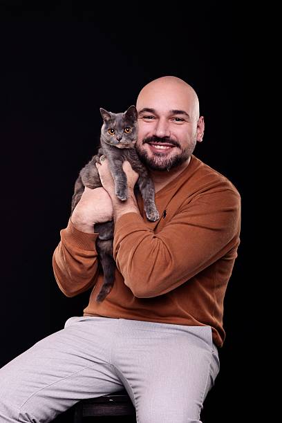 istock muscular man holding an indoor cat 2211414226