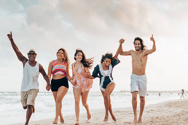 istock happiness friends running together at the beach 2211417155