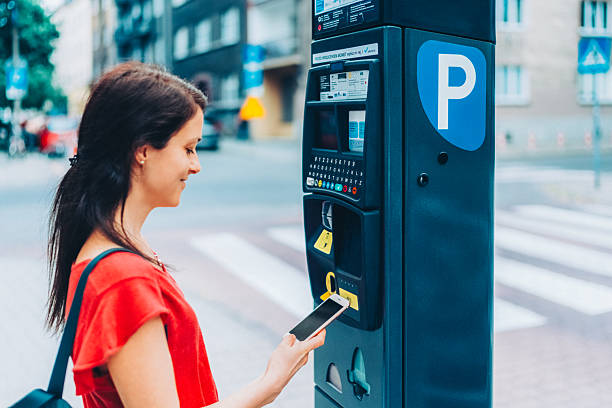 istock Woman using smartphone to pay for parking 2211418328