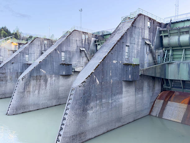 istock Large concrete dam structure with industrial water control gates 2211420135