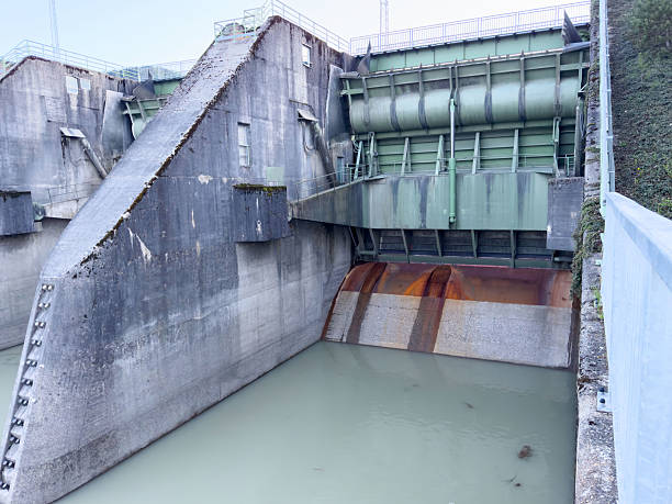 istock Massive dam spillway structure with closed gates and calm water 2211420140