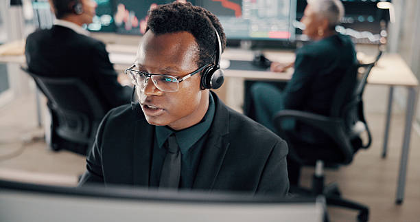 istock Business, headset and man in office, computer and call center with help desk, talking or trading expert. Person, employee or consultant in workplace, headphones or financial advisor with stock market 2211420582