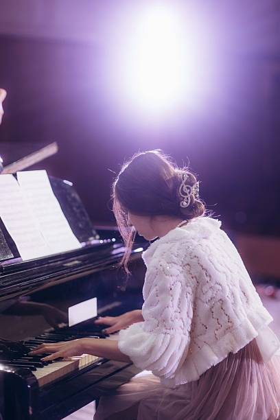 istock Young Pianist Performing During a Warmly Lit Grand Piano Recital 2211422621