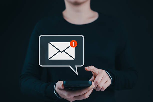 istock New email notification alert concept. A person receiving new message notification on their smartphone. digital envelope icon with a red alert symbol represents incoming email or communication update. 2211423459