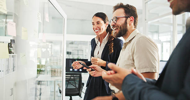 istock Business people, glass wall and planning with creativity, teamwork or excited with ideas for proposal. Success, employee or sales consultant with problem solving, smile or brainstorming for project 2211424482