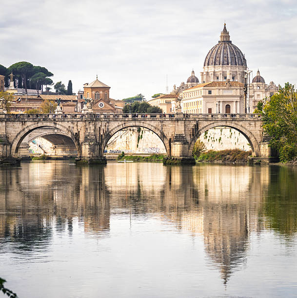 Rome, Italy - A view across the River Tiber on an overcast day during November, with the dome of St. Peter's Cathedral reflected in the water.