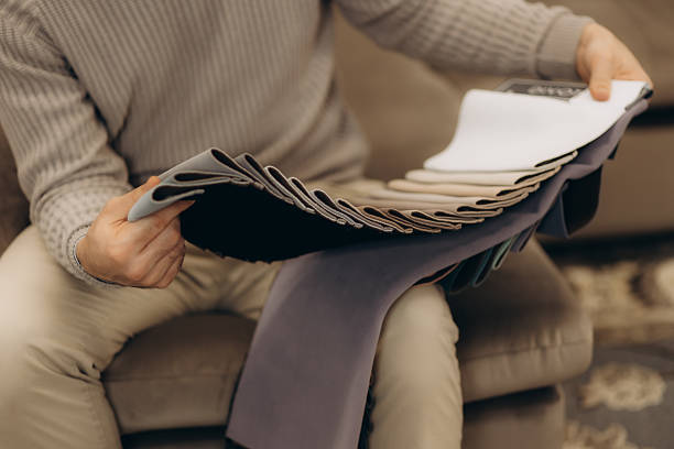 Person Choosing Fabric Samples for Interior Design Decision in Cozy Setting