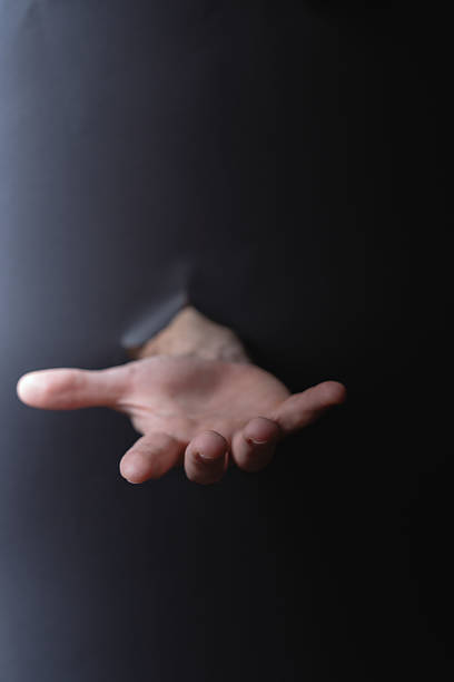 istock photo Human hand extended through dark surface illustration the theme of help offer support and reaching out for connection empathy and communication 2211429554