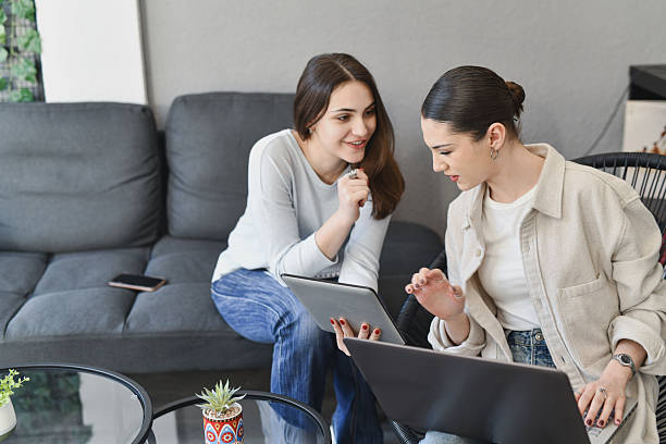 istock Female Employees Discussing Mutual Project on Tablet in Comfortable Sofa 2211436583