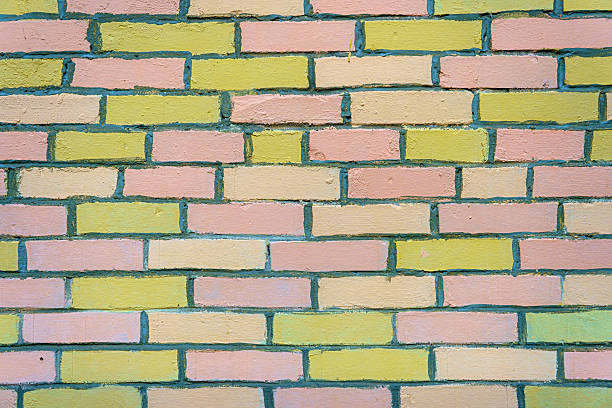 A wall made of pink and yellow bricks. The bricks are arranged in a pattern.