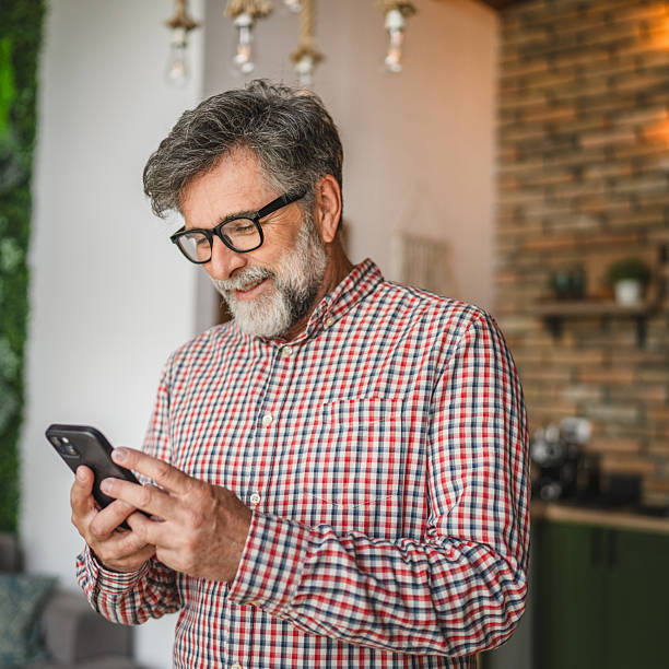 istock happy senior man use mobile phone and have fun at home 2211438192