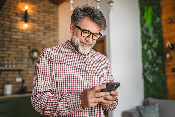 istock happy senior man use mobile phone and have fun at home 2211438264