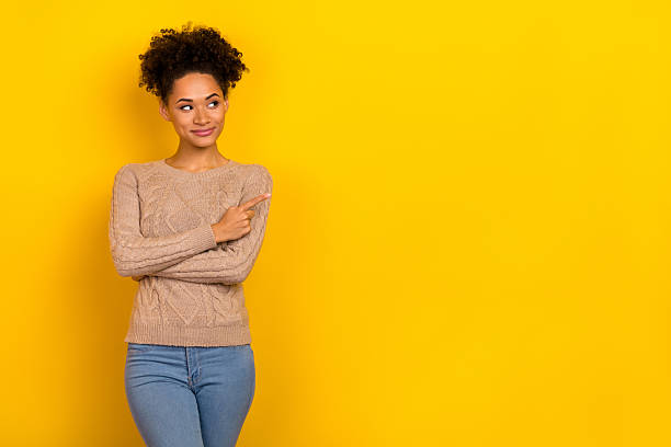 istock Photo of pretty dreamy lady dressed beige pullover looking pointing empty space isolated yellow color background 2211439942