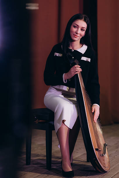 istock Woman Playing Traditional String Instrument on Stage in Formal Attire 2211442191