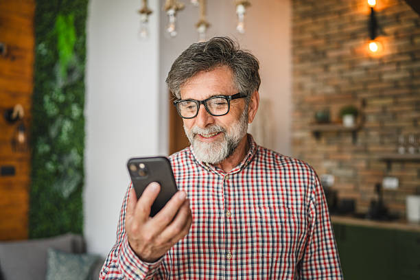 happy senior man use mobile phone and have fun at home