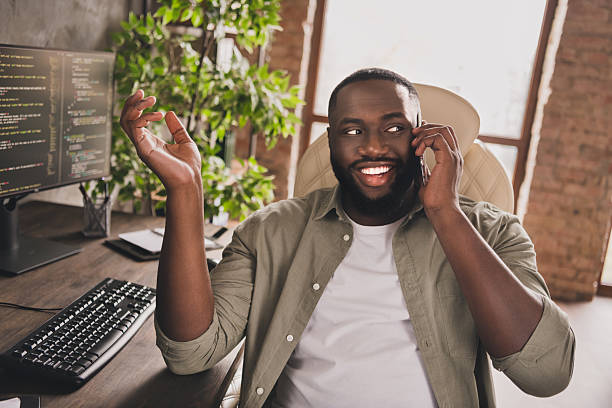 istock Portrait of attractive cheerful skilled guy expert web designer calling client discussing project at workplace workstation indoors 2211445748