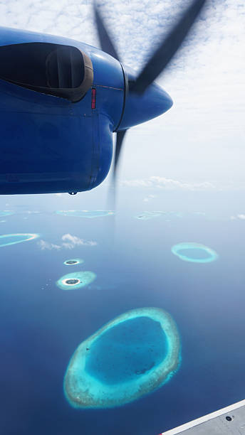 istock Propeller airplane flying over tropical islands in maldives 2211446362