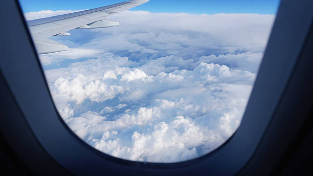 istock Airplane wing soaring above a sea of fluffy white clouds 2211446449