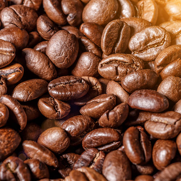 Freshly roasted coffee beans background.Dark roasted coffee beans with scoop on wooden background.