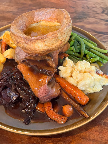 istock Image of roast beef dinner with yorkshire pudding, gravy, carrots, and vegetables / traditional british sunday lunch served hot and hearty 2211447044