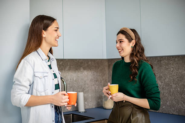 istock Two friends enjoy a lively coffee conversation in a cozy kitchen while laughing and sharing stories 2211447664