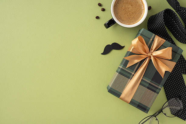 istock Elegantly wrapped gift with a golden ribbon alongside a coffee cup on a stylish setup 2211449204