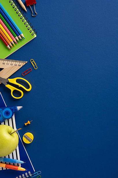 istock School vertical supplies neatly arranged on a blue surface, including stationery and an apple 2211449238