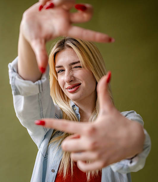 istock Young blonde woman modeling in studio with a playful expression and confident pose 2211449350