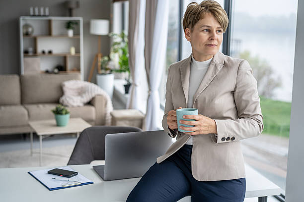 istock Businesswoman Sipping Coffee While Using Laptop and Phone 2211450840
