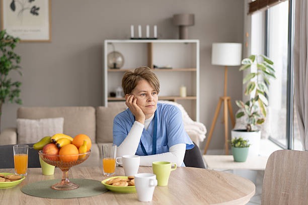 istock Thoughtful woman seated at table with breakfast setting 2211450881