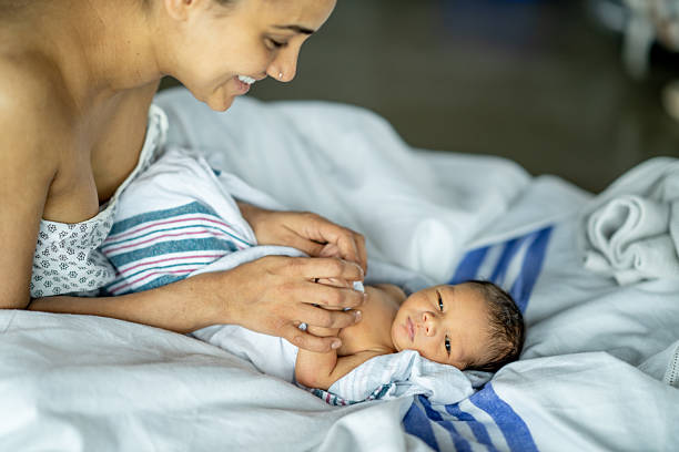 A serene scene of a newborn baby swaddled in blankets, lovingly attended to by a parent, expressing tenderness, warmth, and the nurturing connection of early parenthood.